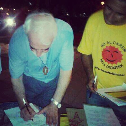 El obispo firmando el petitorio.