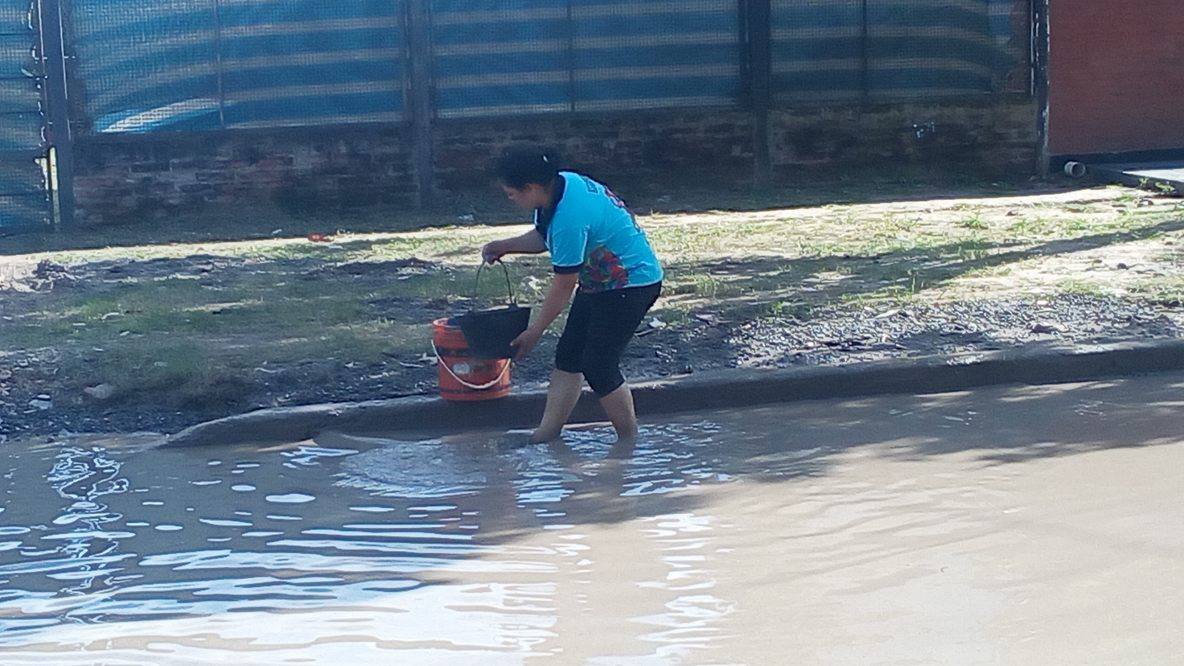 Alumnos secundarios rellenan un bache en el barrio Lote Cuatro