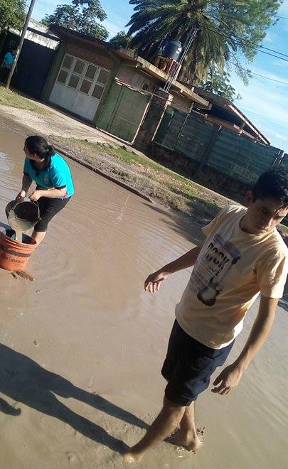Alumnos secundarios rellenan un bache en el barrio Lote Cuatro