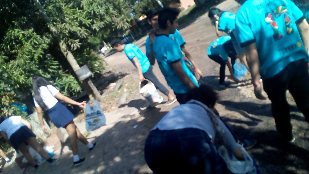 Alumnos secundarios rellenan un bache en el barrio Lote Cuatro