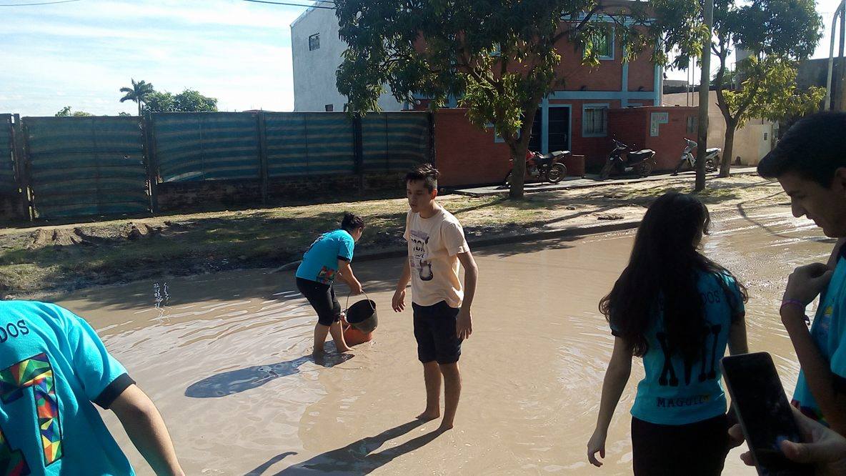 Alumnos secundarios rellenan un bache en el barrio Lote Cuatro