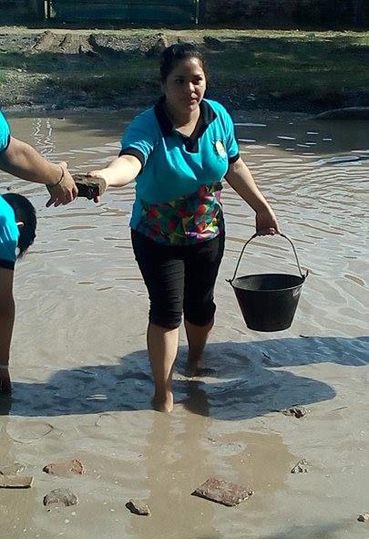 Alumnos secundarios rellenan un bache en el barrio Lote Cuatro