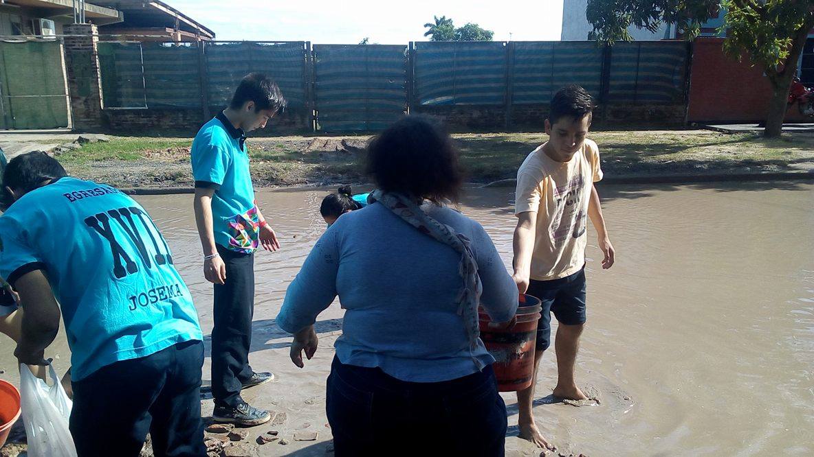 Alumnos secundarios rellenan un bache en el barrio Lote Cuatro