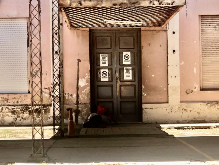 Un hombre indigente duerme en el piso del viejo edificio judicial