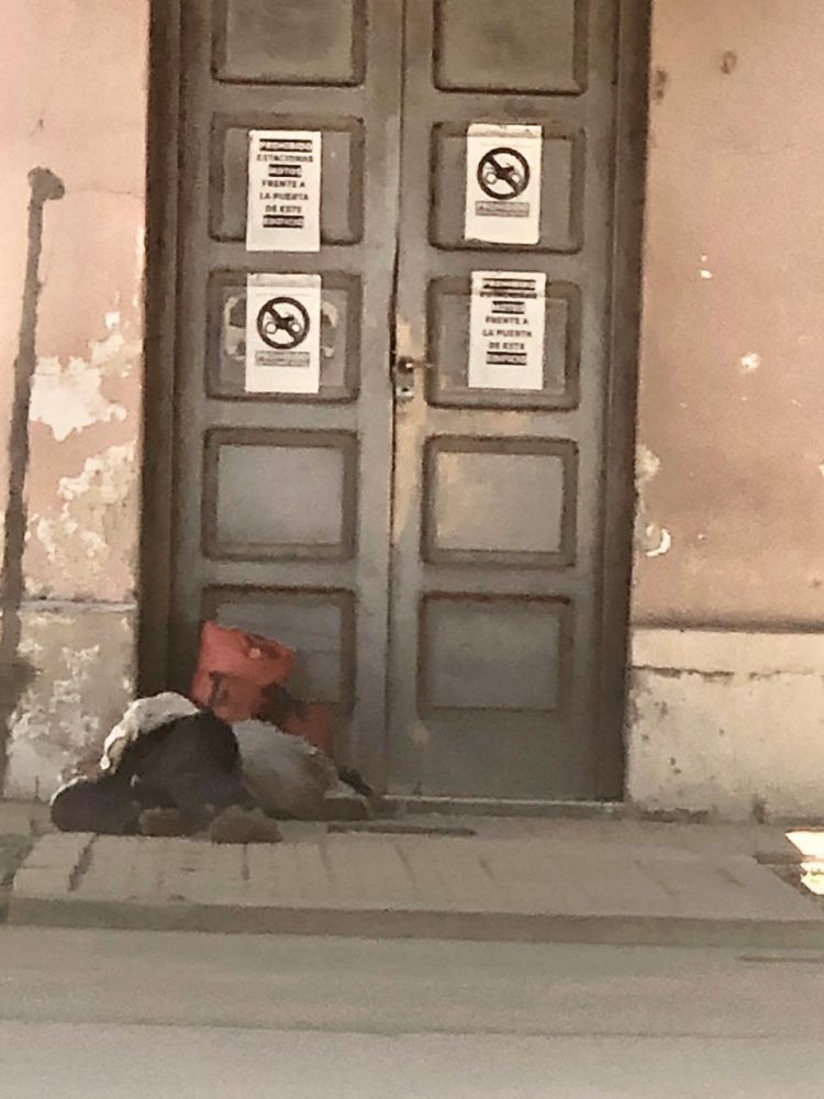 Un hombre indigente duerme en el piso del viejo edificio judicial